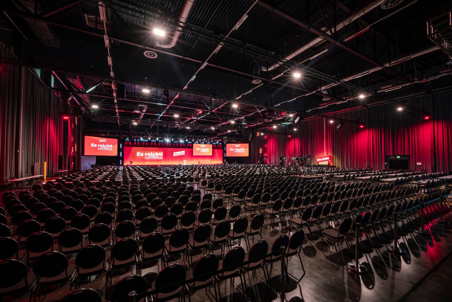 Blick in die Metropolis Halle volle Pax-Bestuhlung mit großer beleuchteter Bühne im Hintergrund.